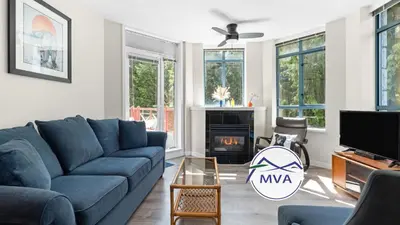 a living room with a blue couch and a fireplace at Alpenglow Lodge Bear Wonder One Bedroom by MVA in Whistler