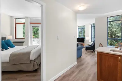 a bedroom with a bed and a bathroom with a sink at Alpenglow Lodge Bear Wonder One Bedroom by MVA in Whistler