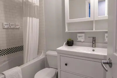 a white bathroom with a toilet and a sink at Alpenglow Lodge Family Studio with Murphy Bed by MVA in Whistler