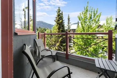a balcony with chairs and a view of trees at Alpenglow Lodge Family & Work Retreat by MVA in Whistler