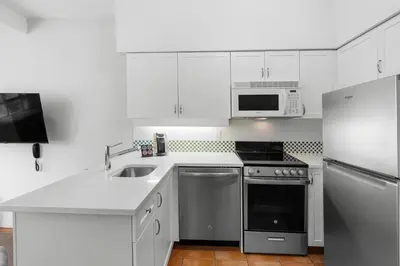 a white kitchen with a sink and a refrigerator at Alpenglow Lodge Family & Work Retreat by MVA in Whistler