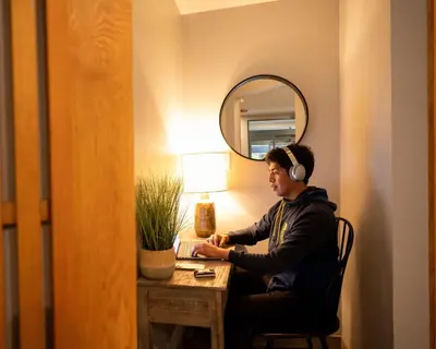 a man wearing headphones sitting at a desk in a room at Alpenglow Lodge Large Studio with Dedicated Work Space by MVA in Whistler