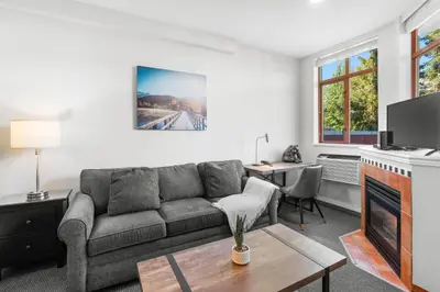 a living room with a couch and a table at Alpenglow Lodge Large Studio with Dedicated Work Space by MVA in Whistler