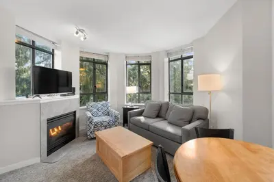 a living room with a couch and a fireplace at Alpenglow Lodge Two Bedroom Apartment with Private Hot Tub by MVA in Whistler