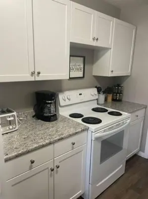 a kitchen with a white stove and white cabinets at Lovely 2 Bedroom apartment in Camrose