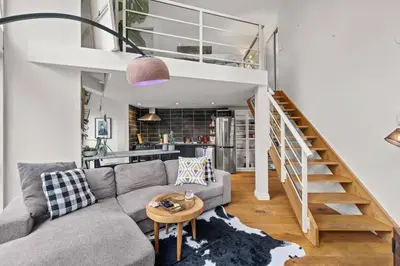 a living room with a couch and a staircase at Beautiful Downtown Loft with full kitchen in Vancouver