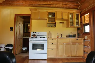 a kitchen with a white oven and wooden cabinets at Bear Valley Highlands in Lumby