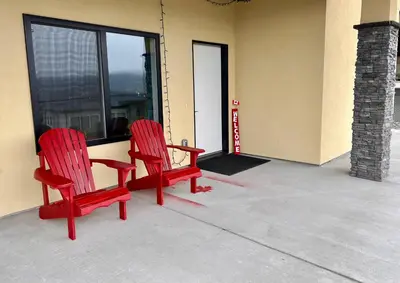 two red chairs sitting in front of a window at Kelowna new lake view 2bedrooms close BIG WHITE in Kelowna