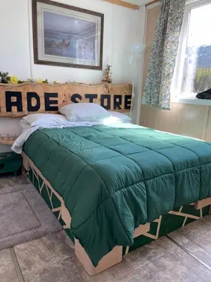 a bed in a bedroom with a green comforter at Jade City Dog House in Jade City