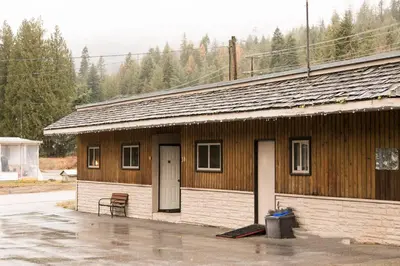 a wooden building with a bench in front of it at Lone Star Motel in Rossland