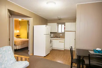 a kitchen with a white refrigerator and a table and chairs at Lone Star Motel in Rossland