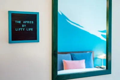 a mirror hanging on a wall next to a bed at The Après, Village Studio with Hot Tub and View in Whistler