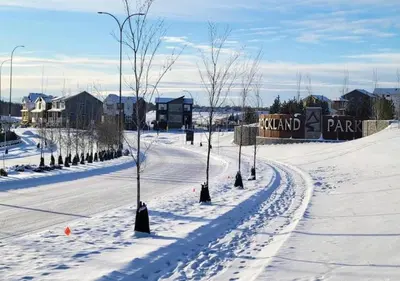 a snow covered street with trees in the middle at Brand New 3-Bedroom Home in a Quiet Neighborhood in Calgary