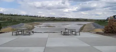 a group of benches sitting next to a river at Brand New 3-Bedroom Home in a Quiet Neighborhood in Calgary
