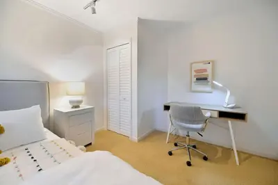 a bedroom with a bed and a desk and a chair at Beachside Living Cherry Point by EMR Vacation Rentals in Cobble Hill