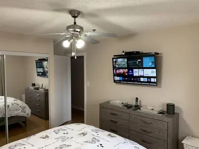a bedroom with a bed and a ceiling fan at Chris Cozy Condo Commonwealth #205 Edmonton in Edmonton