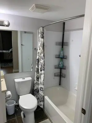 a bathroom with a toilet and a tub and a shower at Chris Cozy Condo Commonwealth #205 Edmonton in Edmonton