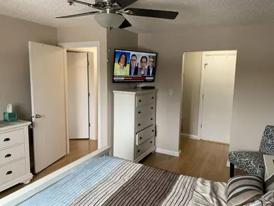 a bedroom with a bed and a flat screen tv at Chris Cozy Condo Commonwealth #205 Edmonton in Edmonton