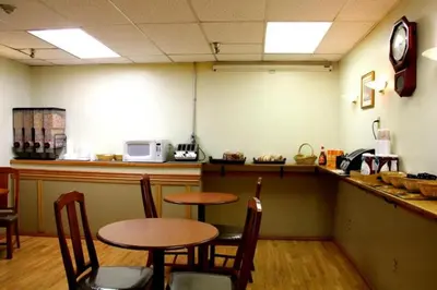 a restaurant with two tables and chairs and a counter at Acorn Motel in Grande Cache