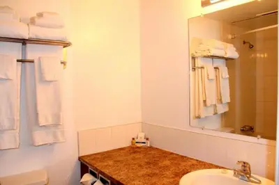a bathroom with a sink and a mirror at Acorn Motel in Grande Cache