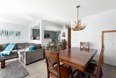 a living room with a table and a couch at 3BR in Sunpath, King Bed, Village Location, Private Patios, Hot Tub and Pool in Whistler