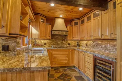 a large kitchen with wooden cabinets and a sink at Mountain Retreat, Panoramic Lake Views in Invermere