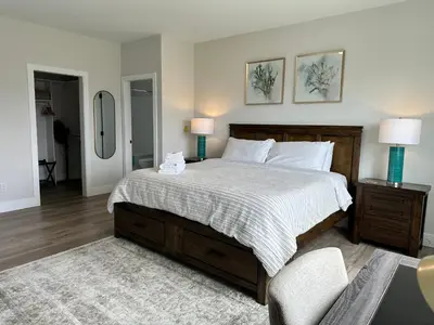a bedroom with a large bed and a chair at Shannon Heights B&B in West Kelowna