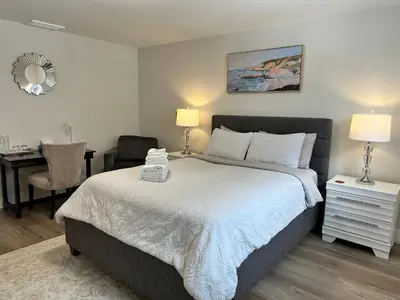 a bedroom with a bed and a desk with a chair at Shannon Heights B&B in West Kelowna