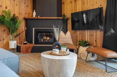 a living room with a table and a fireplace at The Matterhorn I HotTub I Ping Pong I Chalk Wall in Fairmont Hot Springs