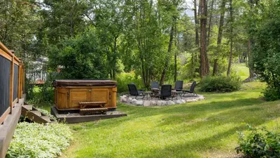 a backyard with a grill and chairs in the grass at The Matterhorn I HotTub I Ping Pong I Chalk Wall in Fairmont Hot Springs