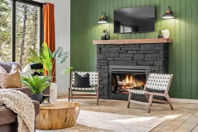 a living room with a fireplace and green walls at The Sleeping Moose I Fireplace I Pool Table I TV in Fairmont Hot Springs