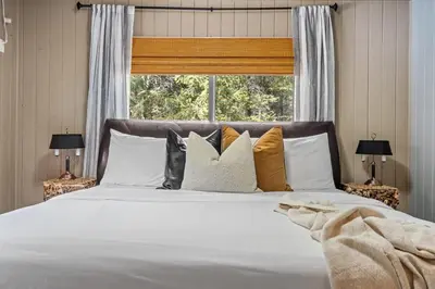 a bedroom with a white bed with pillows and a window at The Sleeping Moose I Fireplace I Pool Table I TV in Fairmont Hot Springs