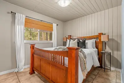 a bedroom with a wooden bed and a window at The Sleeping Moose I Fireplace I Pool Table I TV in Fairmont Hot Springs