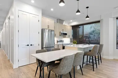 a kitchen with a table and chairs and a refrigerator at Beautiful 2 bedroom town home in Sunrise Ridge in Parksville