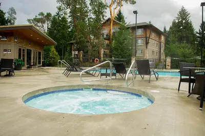 a small swimming pool with chairs and a swing at Beautiful 2 bedroom town home in Sunrise Ridge in Parksville
