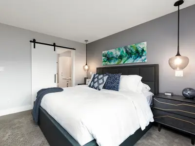 a bedroom with a large bed with white sheets and blue pillows at Beautiful 2 bedroom town home in Sunrise Ridge in Parksville