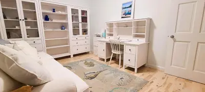 a living room with a white couch and a desk at The White House in Sechelt