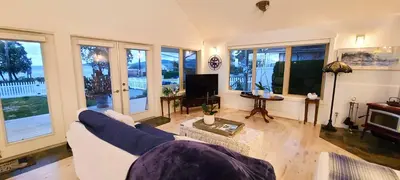 a living room with a couch and a tv at The White House in Sechelt