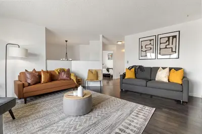 a living room with two couches and a table at Dino Roar I Sleeps 12 I New in Drumheller