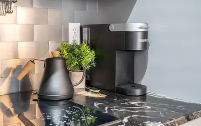a black coffee maker on a counter in a kitchen at Dino Roar I Sleeps 12 I New in Drumheller