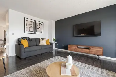 a living room with a couch and a flat screen tv at Dino Roar I Sleeps 12 I New in Drumheller