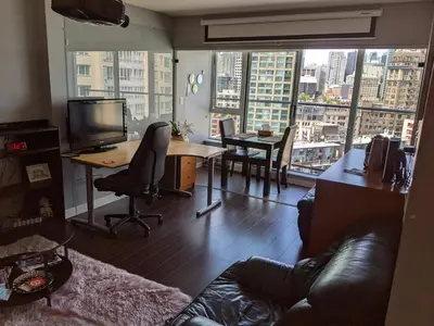 a living room with a couch and a desk with a television at Vancouver Downtown Accommodation in Vancouver