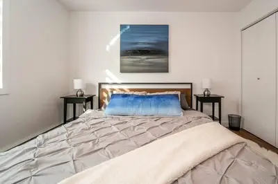 a bedroom with a large bed with two side tables at Spacious 2bedroom FREE parking king bed close to DT in Edmonton