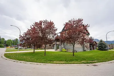 a house with trees in front of a street at Aspen Lodge by Revelstoke Vacations in Revelstoke
