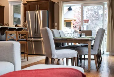 a kitchen with a table with chairs and a refrigerator at Aspen Lodge by Revelstoke Vacations in Revelstoke