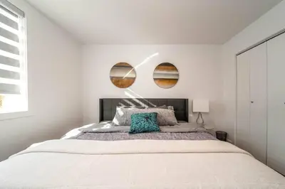 a bedroom with a large bed with two mirrors on the wall at Stylish Close to D/T FREE parking King Bed 2bed in Edmonton