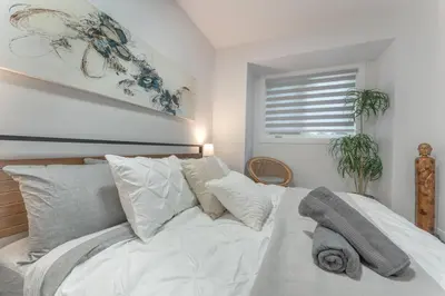 a bedroom with a white bed with pillows and a window at Chic Romantic3bed patio WIFI quiet retreat parking in Calgary