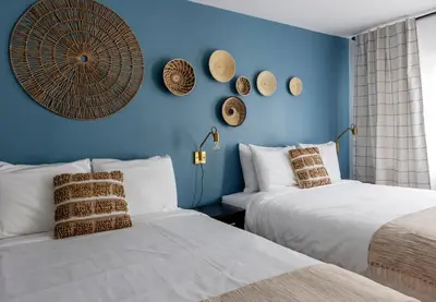two beds in a room with blue walls at Kettle Valley Beach Resort in Penticton