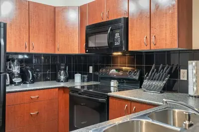 a kitchen with a stove and a microwave at Cozy Mountain I Hot Tub & Pool I Close 2 Lake I TV in Invermere