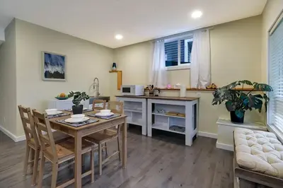 a kitchen and dining room with a table and chairs at Adorable private suite with indoor fire place in Cochrane